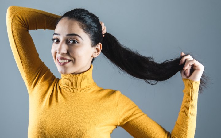 Lang zwart haar en een gele coltrui