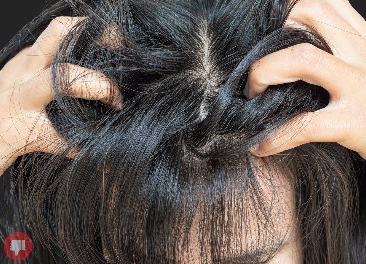 Vrouw die haar hoofd krabt