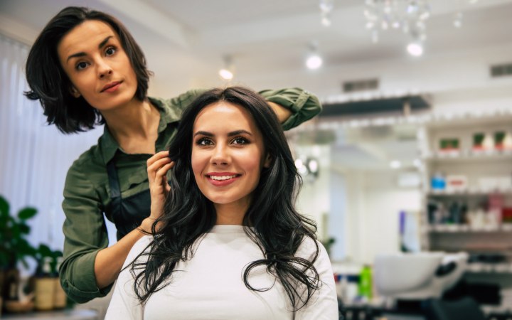 Kapster in haar kapsalon met een klant