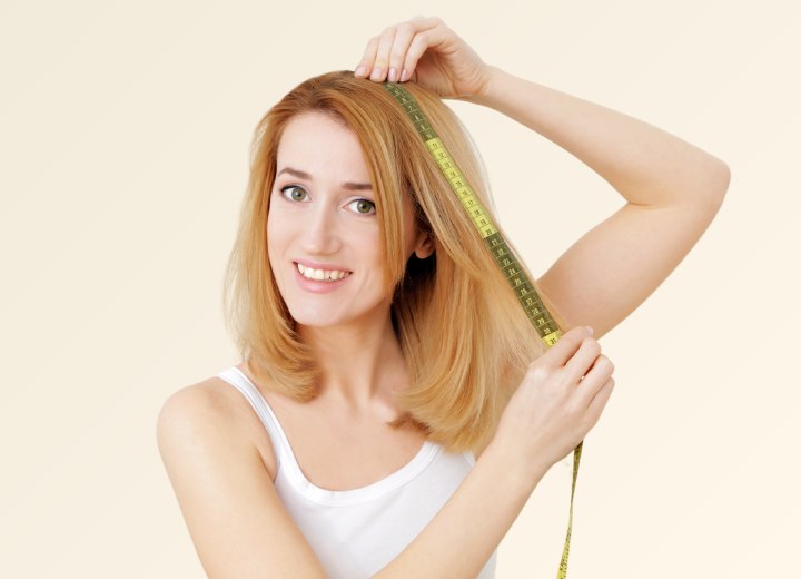Vrouw die de lengte van haar eigen haar meet
