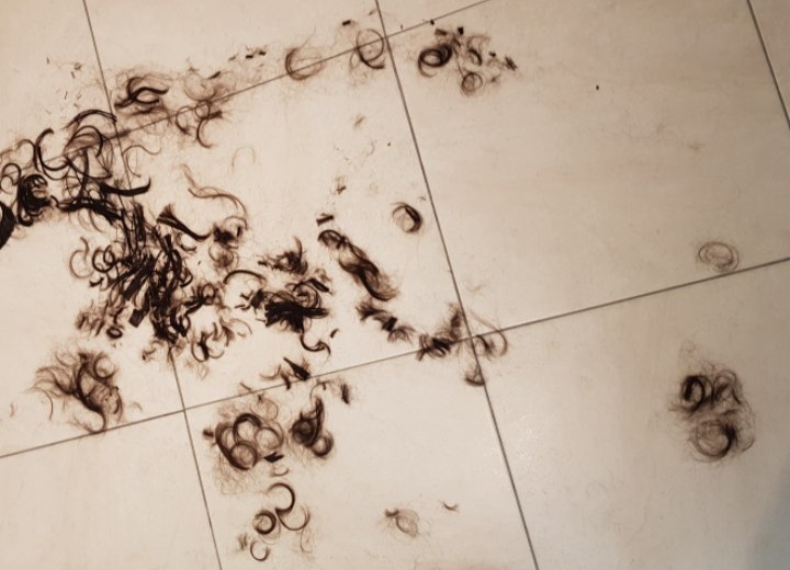 Pas afgeknipt haar dat op de vloer ligt