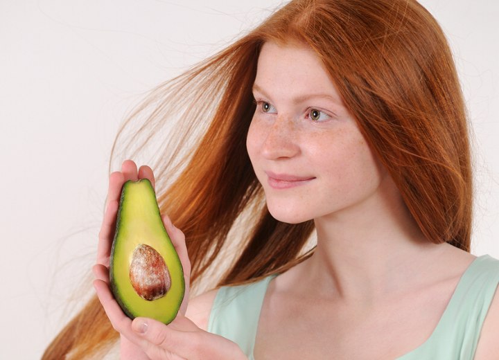 Vrouw met mooi haar en een avocado