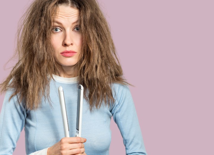 Vrouw die haar haren verbrand heeft met de stijltang