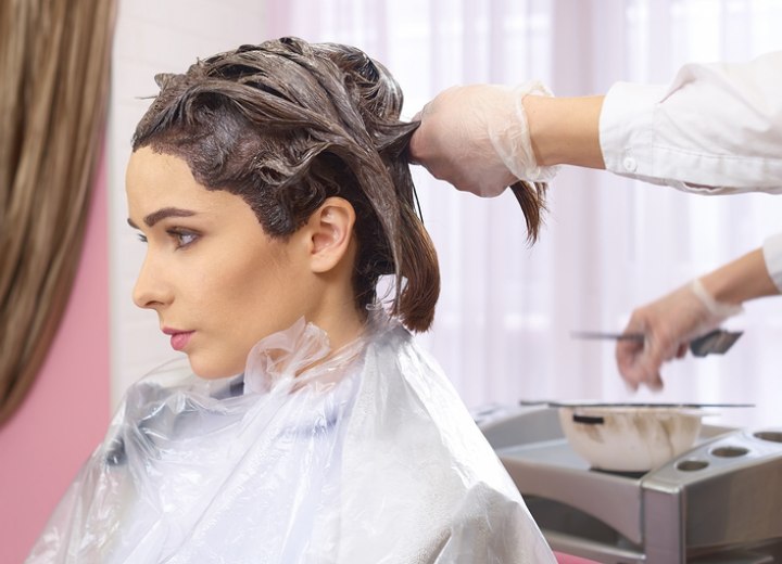 Vrouw die haar haren laat verven bij de kapper