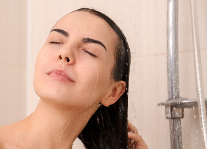 Vrouw die haar haar met koud water wast
