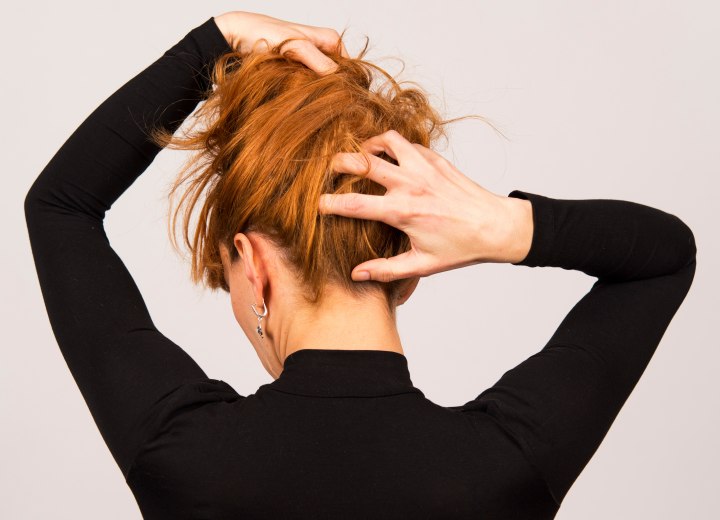 Vrouw die de achterkant van haar haar checkt