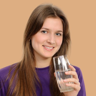 Vrouw die water drinkt voor gezond lang haar