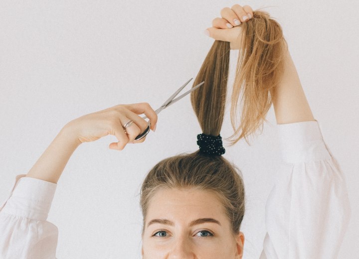 Vrouw die haar eigen haar afknipt