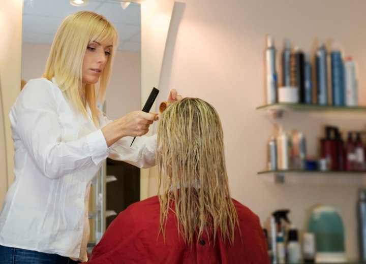 Kapster die haar knipt in haar kapsalon